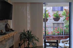 een keuken met een tafel en een balkon met potplanten bij Hermoso apartamento en Girardota in Girardota