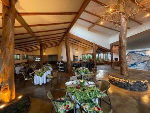 uma sala de jantar com mesas, cadeiras e árvores em Hotel Hotu Matua em Hanga Roa