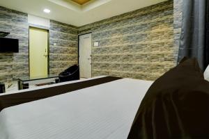Dormitorio con cama, escritorio y TV en Collection O Hotel Leo Inn, en Rajkot