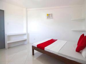 A bed or beds in a room at RedDoorz At Fat J Apartelle Mactan