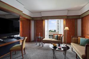 a living room with a couch and a television at The Sukhothai Bangkok in Bangkok