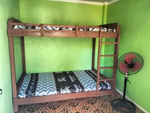a bedroom with two bunk beds and a fan at Sir Louie Lodging House in Majayjay