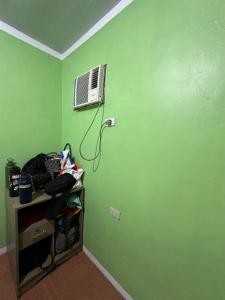 a room with a green wall with a air conditioner at Sir Louie Lodging House in Majayjay