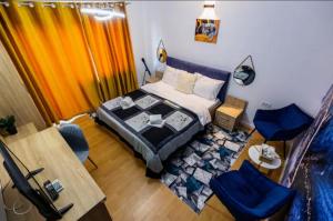 um quarto com uma cama, uma mesa e cadeiras em BLUE em Timişoara