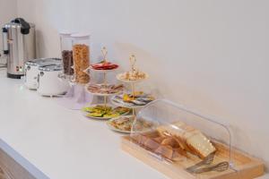 a buffet of food on a counter with plates of food at H-avenue Hotel Munhyeon in Busan