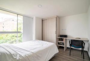 a bedroom with a bed and a desk and a chair at apartamento 602 in Manizales