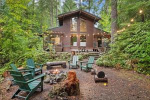 uma cabana de madeira na floresta com cadeiras e uma fogueira em ZigZag Basecamp · Cozy Cabin Perfect for Nature Escapes w/ Hot Tub em Rhododendron