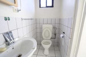 a white bathroom with a toilet and a sink at Nadi Bethel Homestay in Nadi