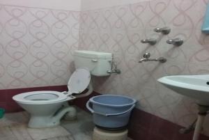 a bathroom with a toilet and a sink at Hotel Teerth Guest House Inn Varanasi in Varanasi