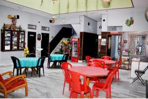 - un restaurant avec des tables et des chaises dans une salle dans l'établissement Hotel Teerth Guest House Inn Varanasi, à Varanasi