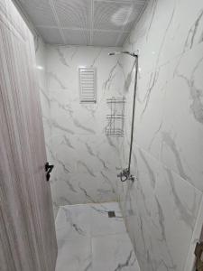 y baño con ducha y pared de mármol. en Esenboğa Yıldırım Beyazıt Apart, en Ankara