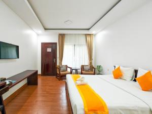 a hotel room with a bed and a television at Angkearboss Villa in Kampot