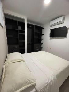 um quarto com uma cama e uma televisão de ecrã plano em HERMOSO APARTAMENTO EN VALLEDUPAR em Valledupar