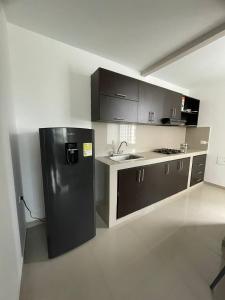 uma cozinha com um frigorífico preto e um lavatório em HERMOSO APARTAMENTO EN VALLEDUPAR em Valledupar