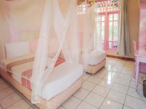 a bedroom with two beds with curtains and a window at BS Home in Kuta