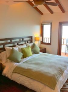 a bedroom with a large bed with green pillows at Amazing Luxury ocean front Hamilton Cove Villa welectric cart in Avalon