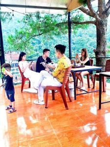 eine Gruppe von Personen, die in einem Restaurant an Tischen sitzen in der Unterkunft Thung Lũng Tình Yêu Homestay Tam Đảo in Vĩnh Phúc