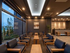 a waiting room with chairs and tables and a bar at Hotel Route Inn Tokushima Airport -Matsushige Smartinter- in Matsushige