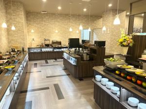uma grande cozinha com uma linha de buffet num restaurante em Hotel Route Inn Tokushima Airport -Matsushige Smartinter- em Matsushige