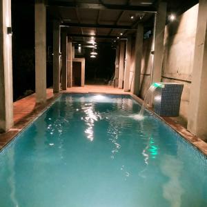 a swimming pool at night with a water fountain at The SKYi County Dapoli in Dapoli
