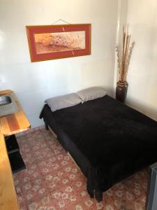 um quarto com uma cama preta num quarto em Hotelito Ejido de la 10 em Puebla