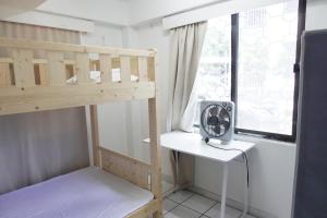 ein Etagenbett mit einem Ventilator und einem Fenster in der Unterkunft Nadi Bethel Homestay in Nadi