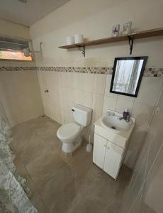 a bathroom with a toilet and a sink at Casa la Picola in Sierpe