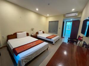 - une chambre avec 2 lits et une télévision à écran plat dans l'établissement Thanh Phúc Hotel, à Dong Hoi