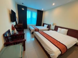 Cette chambre comprend deux lits et une télévision. dans l'établissement Thanh Phúc Hotel, à Dong Hoi
