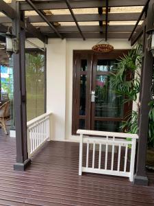 un porche con un banco blanco en una terraza de madera en The Siam Heritage Hotel en Bangkok