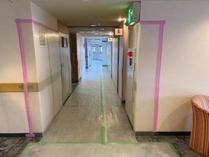um corredor num edifício com paredes cor-de-rosa e brancas em Hotel Regina Kawaguchiko em Fujikawaguchiko