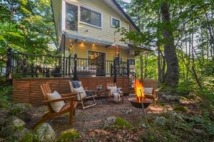 a backyard with a fire pit and chairs and a house at Hakuba Cottage Momiji in Hakuba