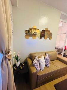 a living room with a brown couch with pillows at Amiela’s Place in Trece Martires