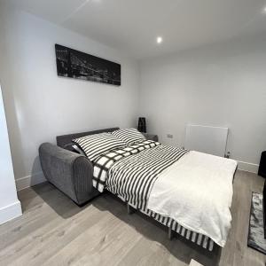 a bedroom with a bed with a black and white blanket at Southborough Suite in Kent