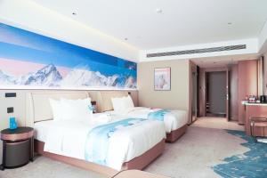 two beds in a hotel room with mountains on the wall at Tianjin Polar Ocean Hotel in Binhai