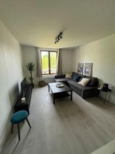 ein Wohnzimmer mit einem Sofa und einem Tisch in der Unterkunft Charmant T3. Spacieux et cosy in Le Mée-sur-Seine