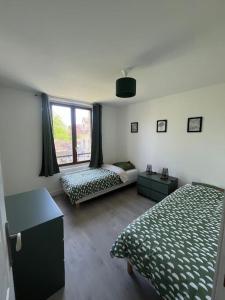 ein Schlafzimmer mit einem Bett, einem Sofa und einem Fenster in der Unterkunft Charmant T3. Spacieux et cosy in Le Mée-sur-Seine