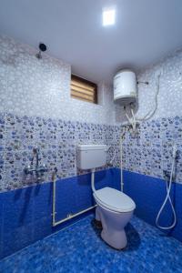 - Baño con aseo en habitación azul en Sri Nandha Luxury Comforts, en Vālpārai