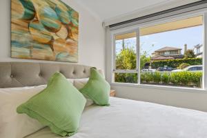 a bedroom with a bed with a large window at StayAU 2BRM Beach Family House Hampton in Melbourne