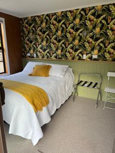 a bedroom with a bed and a wall with a wallpaper at Pyke Cottage, Clyde in Clyde