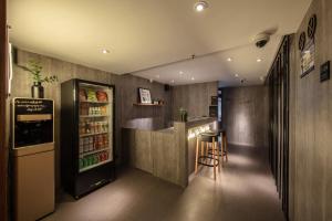 a bar in a restaurant with a refrigerator and a stool at One Forest Youth Hostel - The Bund Branch in Shanghai
