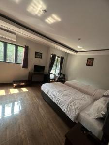 a bedroom with two beds and a desk and windows at NURIS HOTEL in Lampung