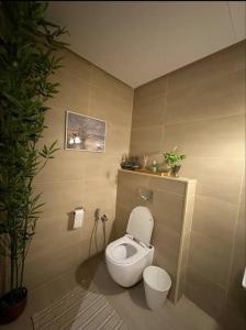 a bathroom with a toilet and a potted plant at Jriska apartment in Riyadh