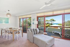 a living room with a table and a couch at Fathoms 8 in Mollymook