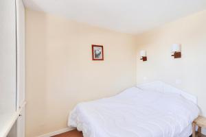 une chambre avec un lit blanc dans une pièce dans l'établissement Résidence Quartier Falaise - maeva Home - 2 pièces 4 pers Confort MAE-5168, à Avoriaz