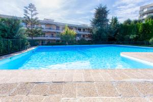 a large blue swimming pool in a building at Sea view apartment in residence with swimming pool! in Nice
