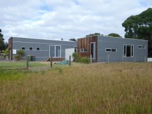 a large metal building in a field of grass at Tranquil Getaway Wifi Netflix Pet friendly in Venus Bay