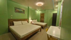 a green room with two beds and a sink at Drossgold Pension House in Tubigon
