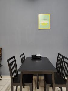 mesa de comedor con sillas y reloj en la pared en Rawang Ho Budjet Homestay en Rawang