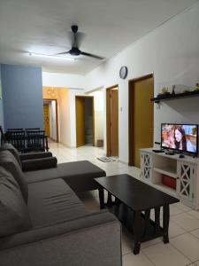 sala de estar con sofá y TV en Rawang Ho Budjet Homestay en Rawang